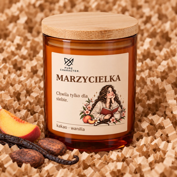 Marzycielka – bursztynowy słoik z etykietą i bambusową pokrywką na papierowym sianku, obok dekoracje zapachowe. Marzycielka — Wanilia. Wizualizacja; dodatki dekoracyjne nie są częścią produktu.