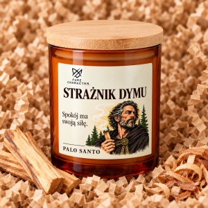 Świeca Strażnik Dymu w bursztynowym słoiku na papierowym wypełniaczu, obok kawałków drewna.